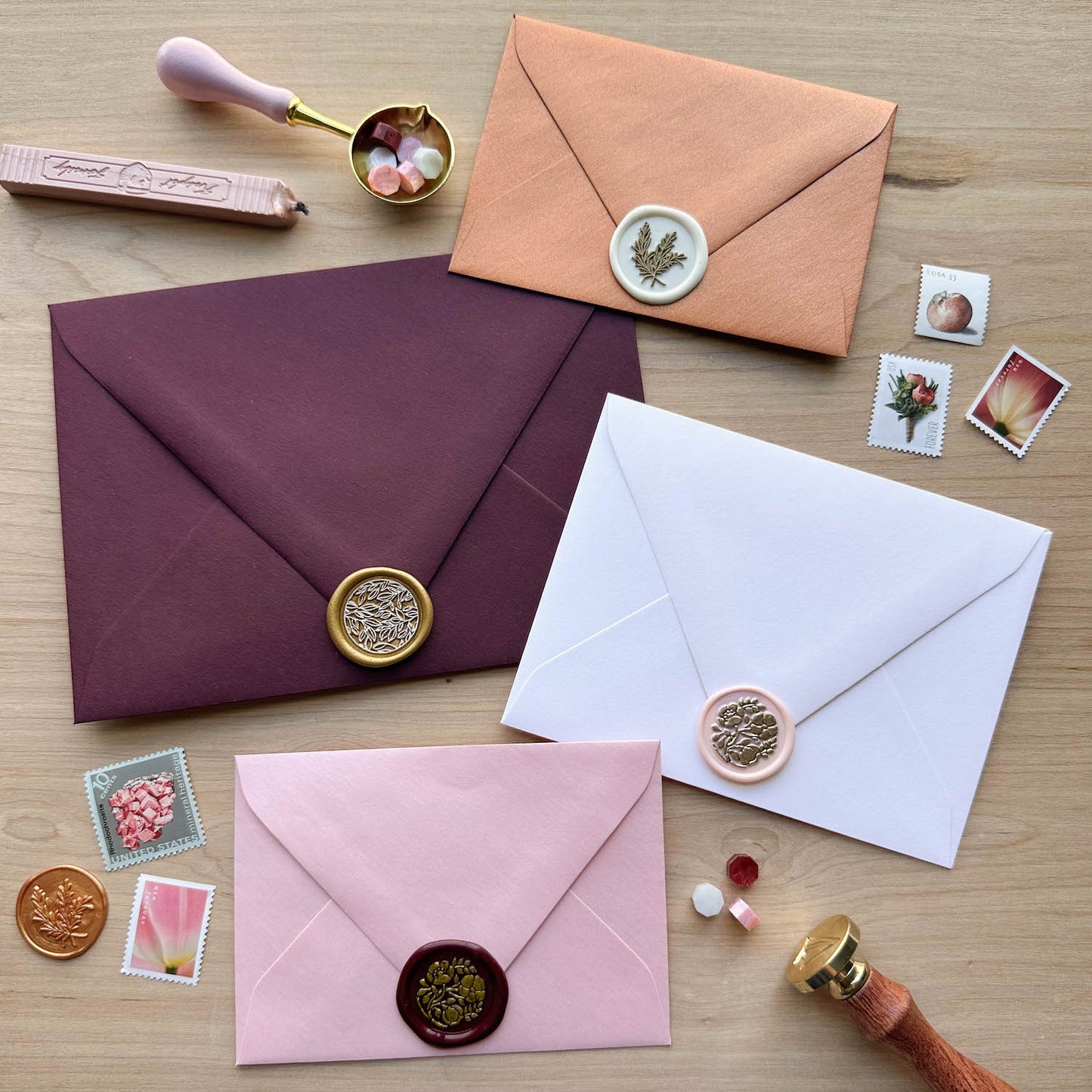 Claret, White Frost, Rose Quartz, and Copper envelopes with wax seals